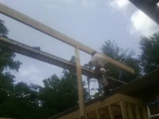 Carpenter setting a ridge beam over a new addition frame — Ice Dam Removal by Roofing Brothers in Wallkill