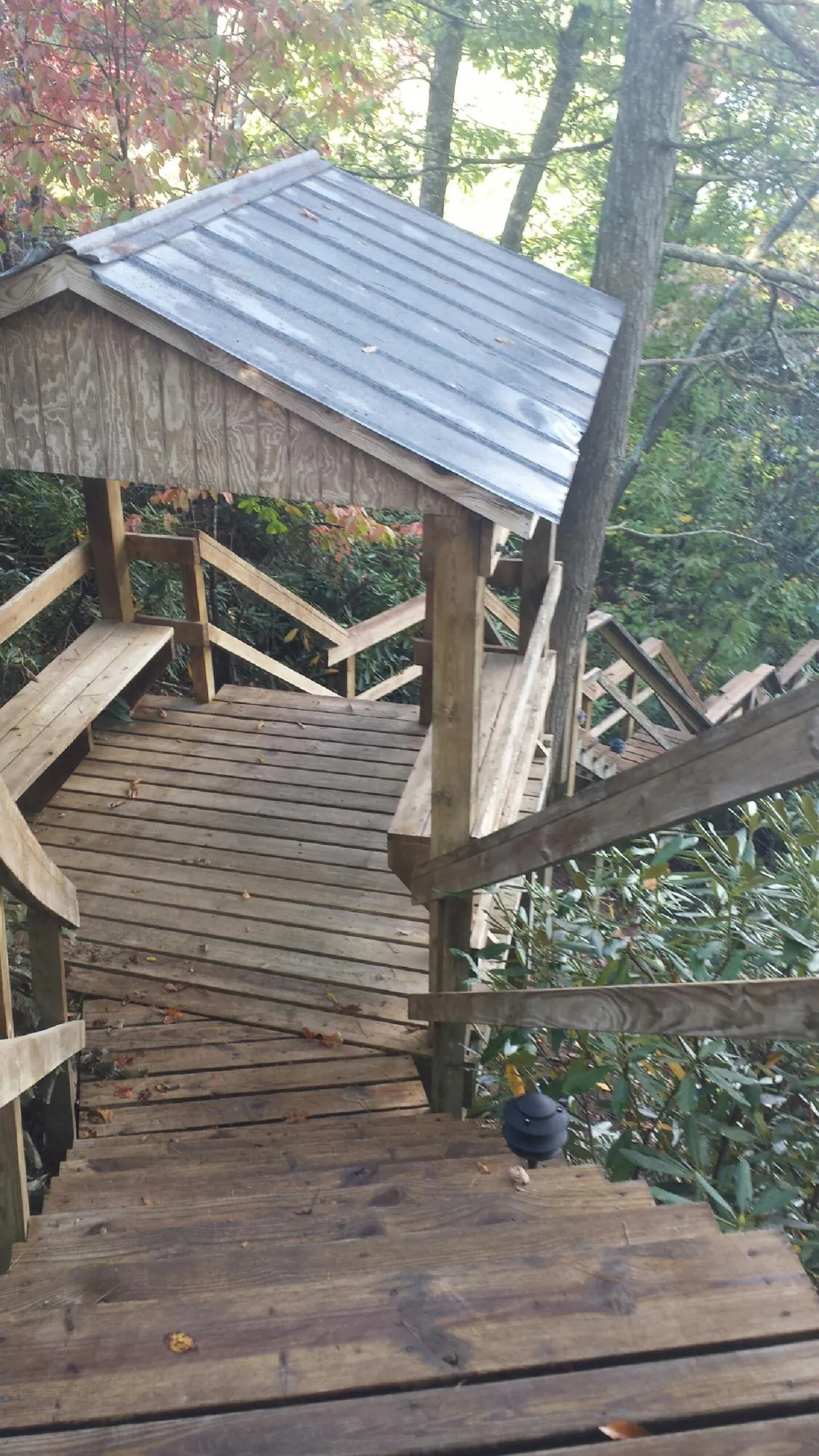 Metal roofed shelter over wooden steps on a wooded walkway — Skylight Repair & Installation work by our crew in Wallkill